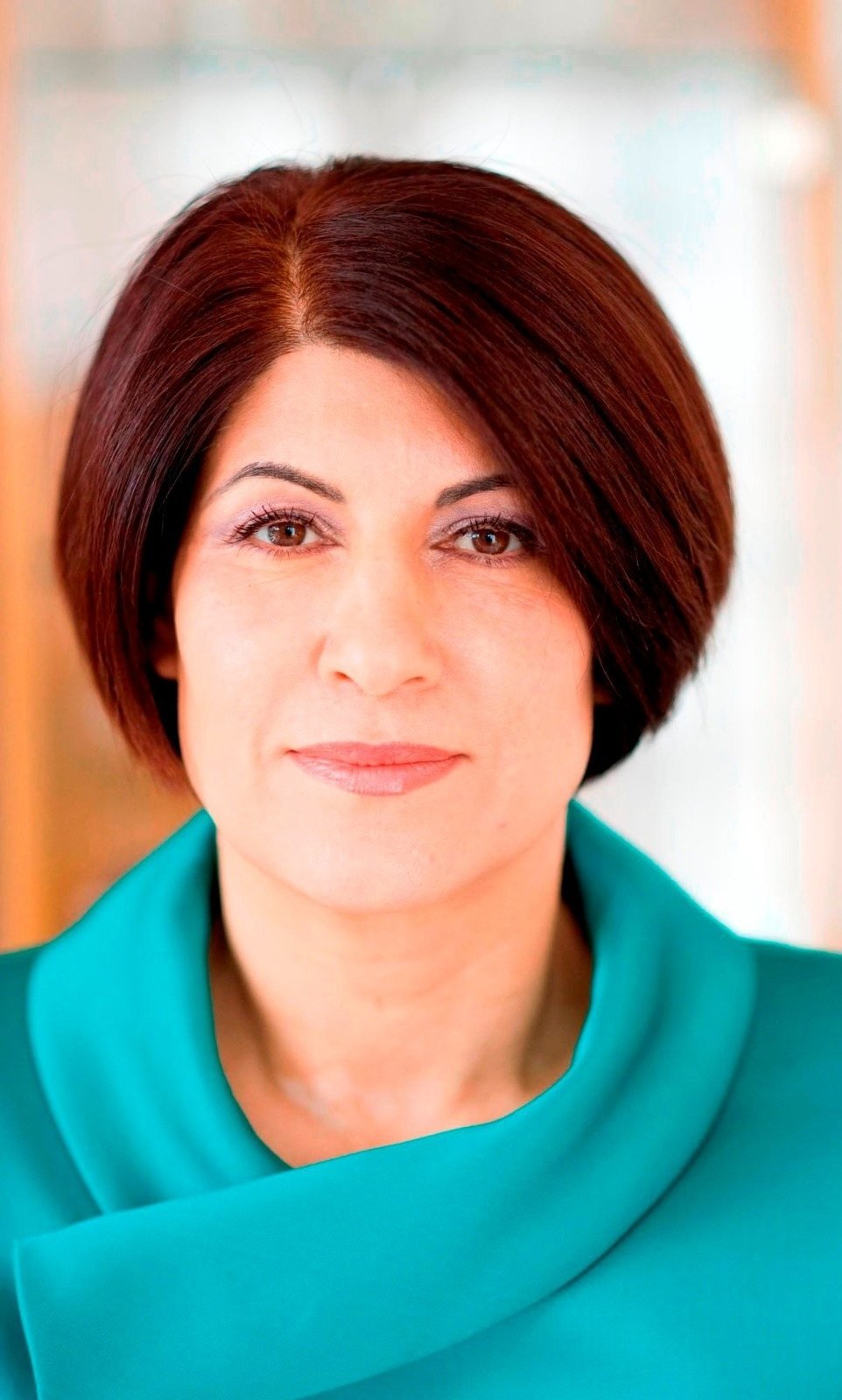 Portrait of Sedika Weingärtner in a turquoise jacket.